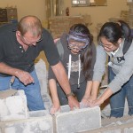 Faculty member Richard Motter helps a duo maneuver a block into place. Faculty member Richard Motter helps a duo maneuver a block into place.