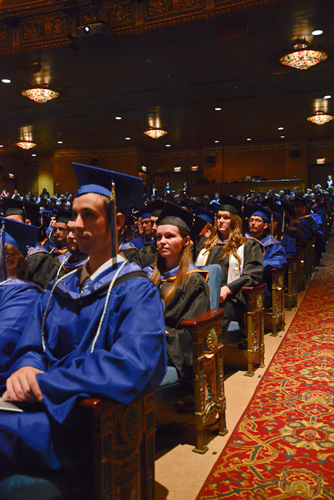Gowns of blue (associate degree students) and black (baccalaureate candidates) fill the center orchestra section.