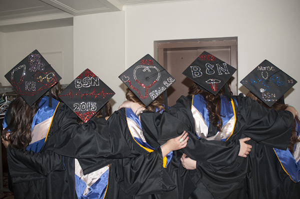 Nursing graduates show the results of their cap-decorating “party.”