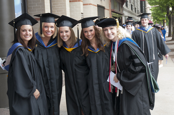 Graduates from the School of Health Sciences pause with Tina M. Evans, associate professor of applied health studies.
