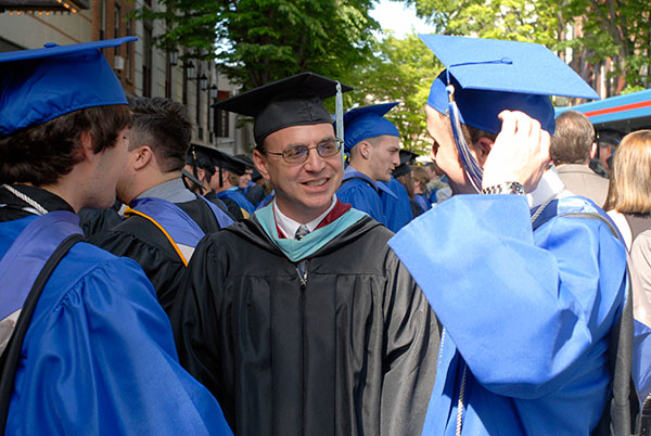 Christopher H. Van Stavoren, an assistant professor of automotive technology (center), reconnects with students after Friday's ceremony.