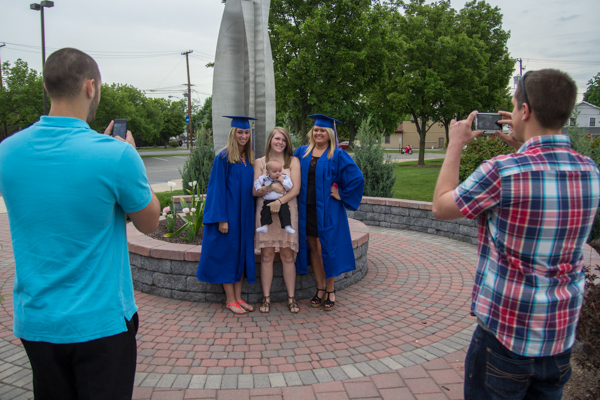 Friends help early childhood education graduates Kirstie A. Swisher (left), and Kelsey A. McGarry preserve a memory in the college's Remembrance Garden.