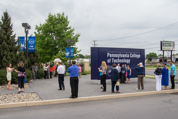 Penn College's entrance sign poses a fitting backdrop for graduates and families capturing one last photo before their exit ...