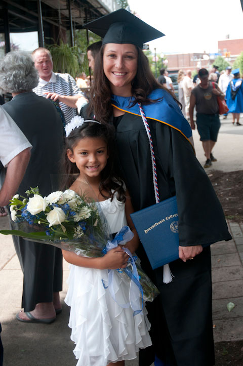 A child totes Penn College-blue flowers for her graduate.