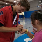 ... and Drew Anderson autographs a girl's hand.