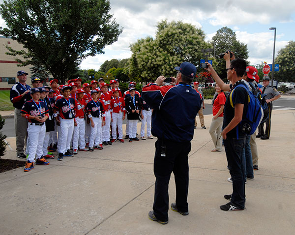 Teams from the Mexico and Mid-Atlantic regions intermingle for photographers after their shared bus ride from the Little League complex.