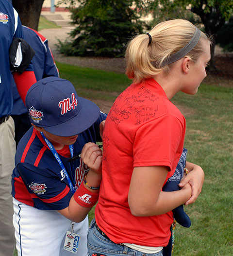 A member of the Mid-Atlantic team from Newark, Del., squeezes his name onto the crowdedly signed T-shirt of student volunteer Lauren J. Crouse, an applied human services major.