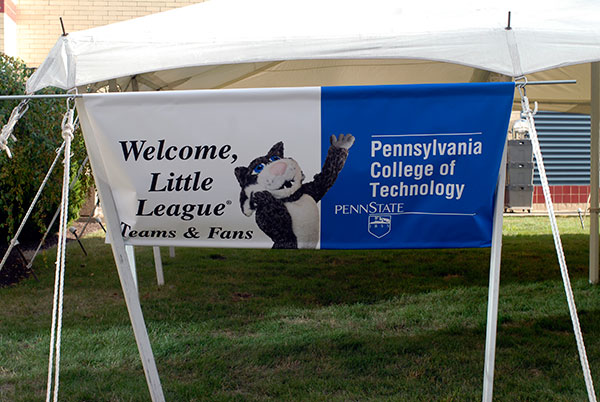 The college mascot welcomes players and guests on a banner outside the food tent.