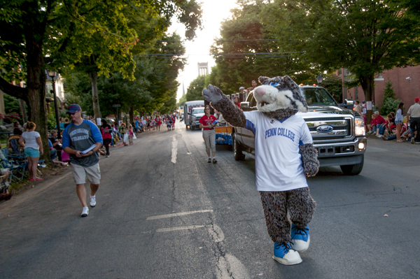 The Wildcat waves to its adoring fans, followed by the Penn College float.