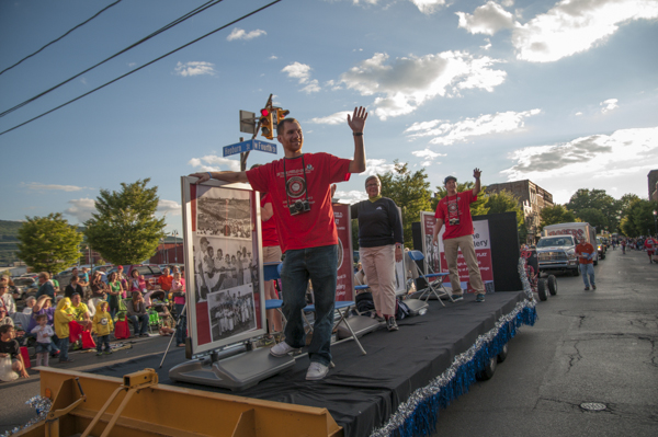 Riding a float that promotes an exhibit of World Series photos by legendary local photographer Putsee Vannucci, are (from left) Bryan L. Coffey, President Gilmour and Daniel S. Honovic, a building automation technology student.