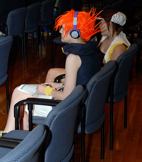 A colorfully coiffed cosplayer enjoys a presentation in the Campus Center.