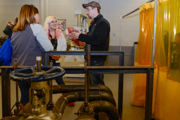 Harry A. Lehman IV, a 2009 welding technology graduate, talks with a potential student and her mother in the Avco-Lycoming Metal Trades Center.