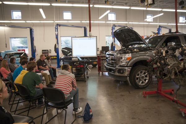 In the Automotive Technologies Center, students watch a demonstration of the latest computer-based diagnostic equipment as it interacts with a 2011 Ford Power Stroke diesel engine.