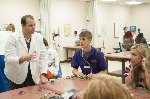 Physician assistant student Filippo D. Borsellino talks with high schoolers about the types of breathing sounds they’re observing.