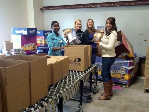 Penn College students enrolled in a Community Health Nursing class fill boxes at the Central Pennsylvania Food Bank’s Williamsport Warehouse. They are, from left, Alvine N. Taylor, Williamsport; Ashley L. Farabaugh, Hatboro; Melissa M. Frank, Towanda; and Priya B. Patel, Morganville, N.J. (Photo provided by the School of Health Sciences)