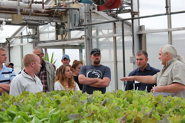 Dennis P. Skinner, assistant professor of horticulture, leads alumni and their guests on a tour of the ESC hydroculture garden.