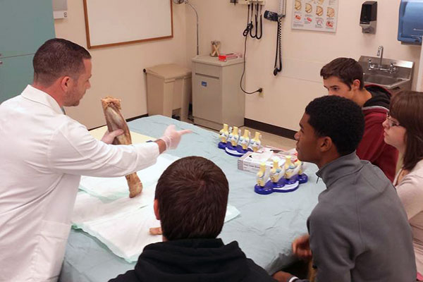 Physician assistant student Jason A. Genco engages participants with an anatomy lesson – illustrated by a human leg that visitors were able to hold in their hands.
