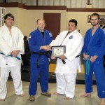 From left are student Alexander J. Hilton, promoted to green belt; Dr. William B. Urosevich, former coach of the Wildcat Power Team; current coach Emmanuel A. Balaguer, promoted to second-degree black belt; and alumnus Logan T. Goddard, the year's outstanding jujitsu athlete and instructor.