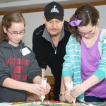 Charles Fazzino watches as students add dimension to the anniversary artwork.