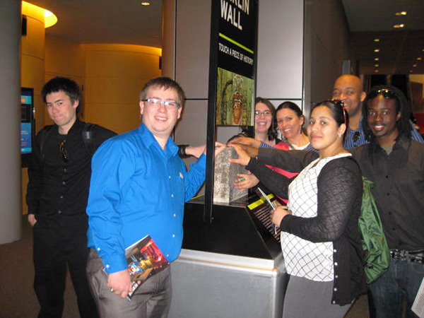 The group visits the Newseum, taking an opportunity to touch a piece of the Berlin Wall ...