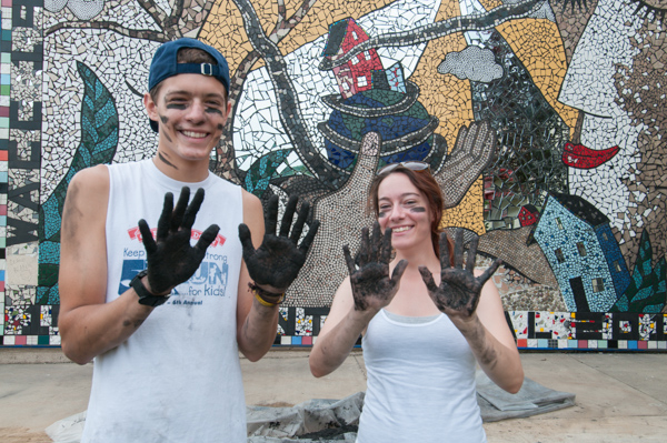 John M. Good IV, an engineering design technology major from Williamsport, and Emmalee J. Williams show off their grout-dirty hands and athletic face paint. 