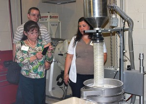 Margie Chappell, of Elkamet, East Flat Rock, North Carolina, takes a photo of a powder classifier as Brock Snyder, of Akro-Plastics in Kent, Ohio, and Shelby Fischer, a PIRC research assistant and plastics and polymer technology major, observe. 