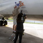 The multimedia journalist captures "B-roll" footage of David E. Maurer, assistant lab coordinator, as he works on an overlay acknowledging the FedEx donation.