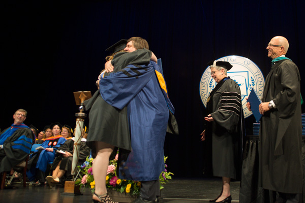 Jacob R. Miller, an associate professor of computer information technology, hugs his daughter, Heather A., who graduated in physician assistant.