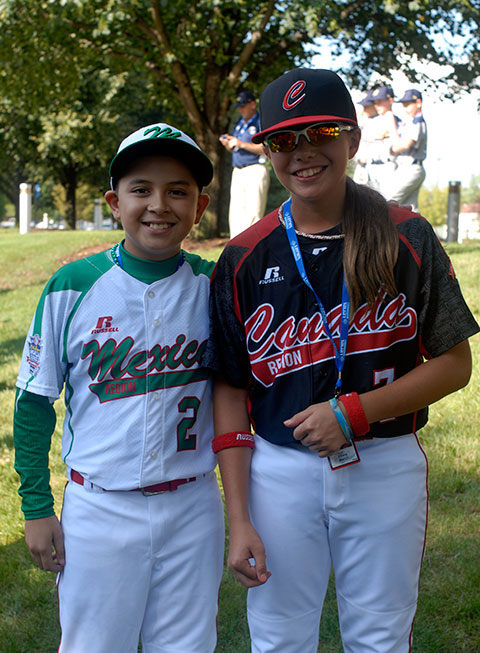 Canada pitcher Emma March, one of two girls in this year's Series, buddies up with Mexico's Rolando Reyna. 