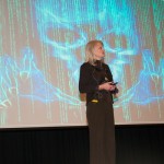 Lisa R. Bock addresses her audience, before the eerie specter of online treachery.