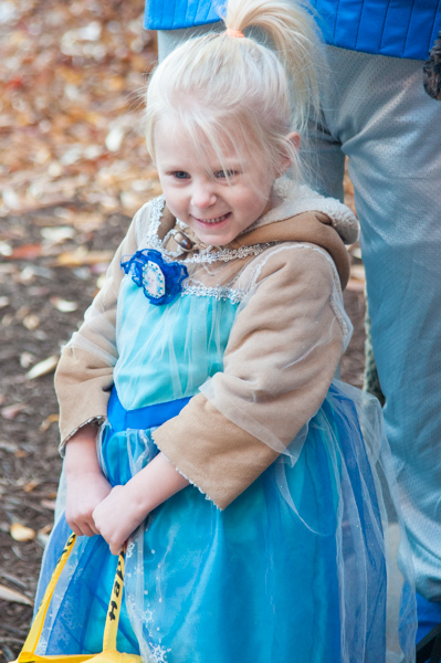 A ponytailed princess keeps a two-fisted grip on her Halloween haul.