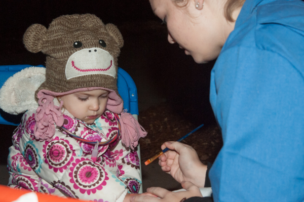 A monkey-hatted model prepares for her brush with an artist.