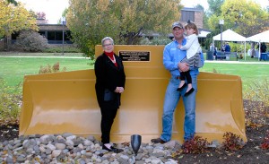 Larry Allison Jr. and his daughter, Sadie, join Penn College President Davie Jane Gilmour in front of a heavy-construction equipment blade on the campus site of the former Lycoming Construction Co., predecessor of Allison Crane & Rigging. The Allison family has established a scholarship fund at the college.