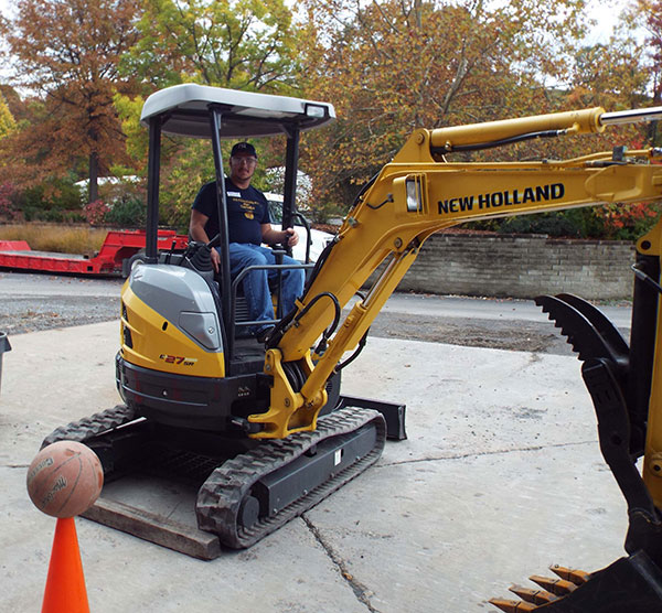 A Monroe Career and Technical Institute student attempts the challenging Basketball Grab with an excavator.