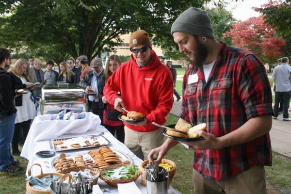 Wesley J. Moomaw, a 2011 welding technology graduate, leads a cookout chow line, followed by David P. Young, a sophomore in welding and fabrication engineering technology from Spring Mills.