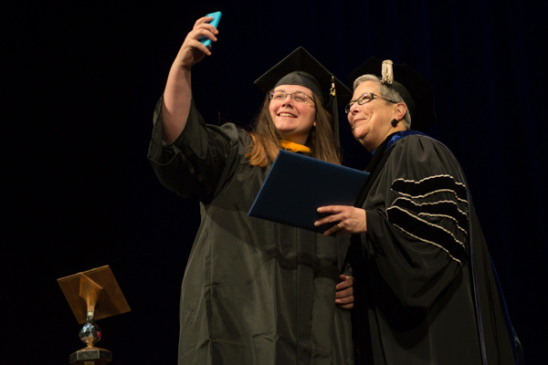 Following the president's orders, a grad is all too willing to freeze the festivities via photos.