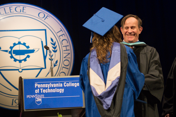 Robert I. Mitchell, associate professor of mathematics, presents a diploma to his daughter, Claire N., who graduated in individual studies.