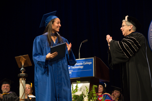 Gilmour signs her congratulations to Reyes-Molina, who also received the Board of Directors Award. Among those watching with pride is Marc E. Bridgens (left), her School of Construction & Design Technologies dean.