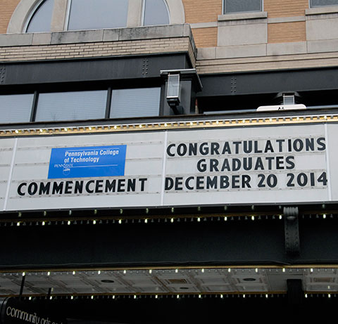 A congratulatory message overhangs its street-level audience outside the CAC.