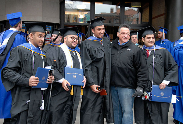 John R. Bartolomucci (second from right), assistant professor of plastics technology, stands in celebration and solidarity with his students.