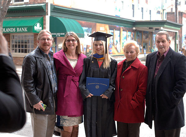 Nursing grad Adriane D. Maurer is awash in encouragement during a photo op outside.