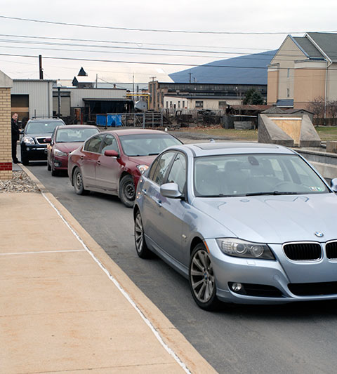 Hagan Way is choked with vehicles as graduates return for a parting shot by the Penn College sign at the main entrance.