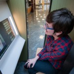 A Public Relations & Marketing co-worker temporarily assumes camera duty for Dalaney T. Vartenisian, seated for a personal perspective on her photo assignment.