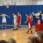 The appropriately clad team mascot cheers the men's team, as James Boylan (33) and Thomas Ross (22) go to work.