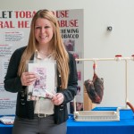 Mohr holds a student "quit packet," available through College Health Services in the Bush Campus Center. Behind her, real pig lungs convincingly replicate smoking's ill effects: the charcoal color of once-pink tissue.