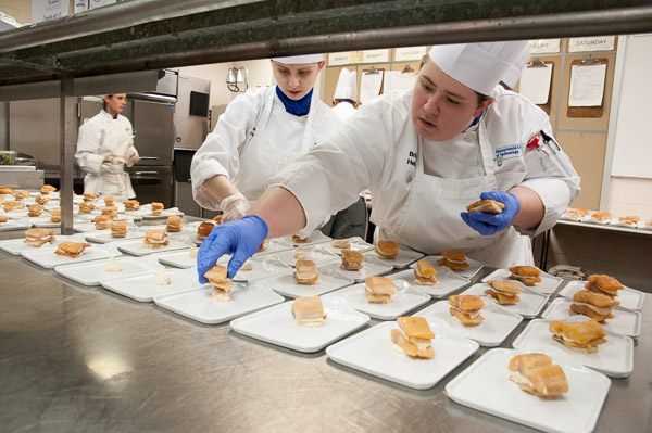Culinary arts and systems students Sarae D. Davis (left), of Nescopeck, and Brianna R. Helmick, of Hershey, help to assemble a “trout napoleon” for the first course.