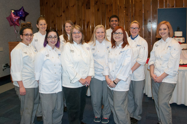 Competitors – all enrolled in the Cake Decorating II course taught by Mayer – pose with their instructor.
