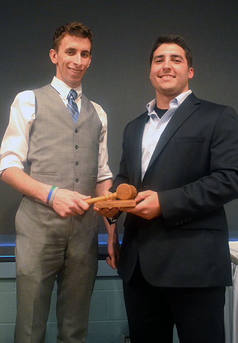 Next year's SGA President Zachary T. Peachey accepts the gavel from predecessor Ryan A. Gibson in an annual tradition.