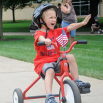 A child waves to an adoring crowd.