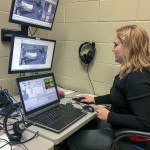 From the control room, Jessica L. Bower, simulation laboratory coordinator for nursing education, observes students and plays the role of patient.